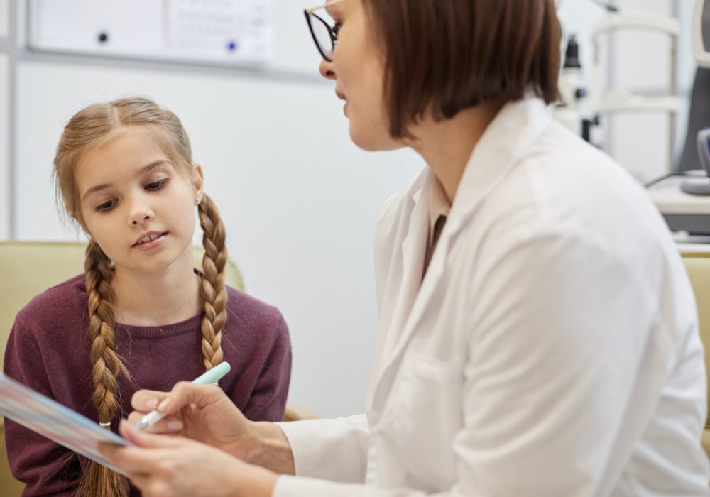 Female Ophthalmologist Talking to Little Girl